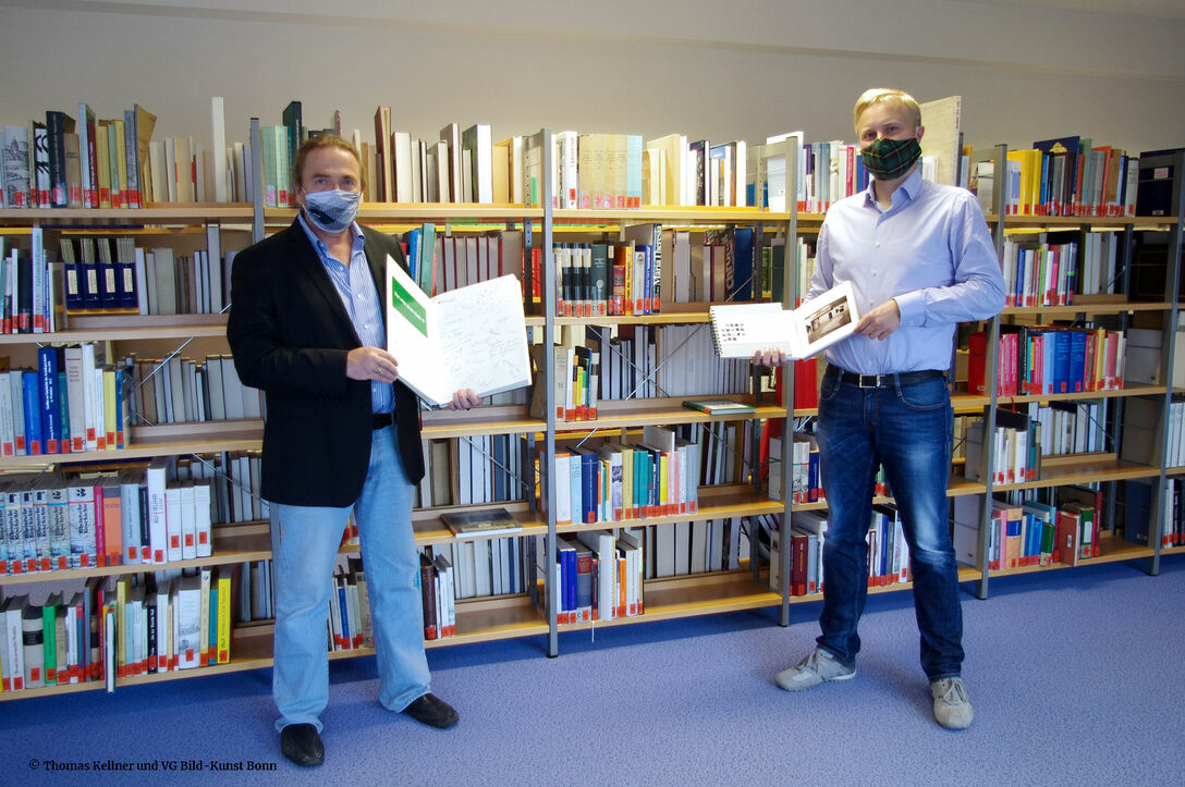 Thomas Kellner presents his gifts, guestbook, documentations and files with Dr. Sturm.